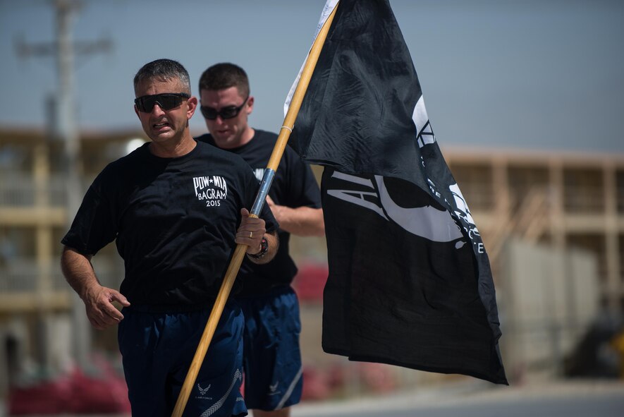 U.S. Air Force Brig. Gen. Dave Julazadeh, 455th Air Expeditionary Wing commander, carries the prisoners of war, missing in action flag during the POW/MIA run at Bagram Airfield, Afghanistan, Sept. 3, 2015. For 24 straight hours, BAF Service members kept the POW/MIA flag in constant motion in honor of American prisoners of war and those missing in action. (U.S. Air Force photo by Tech. Sgt. Joseph Swafford/Released)