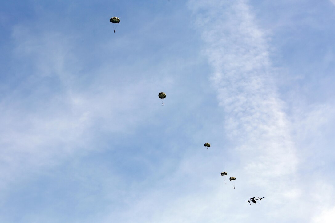 Marines with 2nd Radio Battalion, II Marine Expeditionary Force, conduct static line jumps out of an MV-22 Osprey during parachute operations at Marine Corps Auxiliary Landing Field Bogue, N.C., Sept. 2, 2015. The Ospreys were provided by Marine Medium Tiltrotor Squadron 264, 2nd Marine Air Wing. The Marines jumped from an altitude of 1,250 feet. (U.S. Marine Corps photo by Cpl. Joey Mendez/ Released)