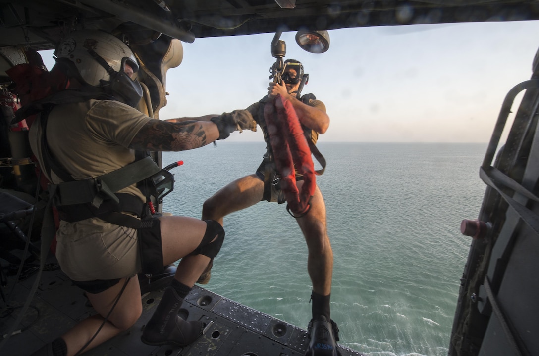 U.S. Navy Seaman Jason Rypkema prepares to exit an MH-60S Seahawk helicopter during search and rescue training with Helicopter Sea Combat Squadron 26 over the Arabian Gulf, Aug. 15, 2015. Rypkema is an aircrewman. Search and rescue swimmers play a key role in personnel safety and mission readiness of U.S. Navy operations. U.S. Navy photo by Petty Officer 1st Class Joshua Bryce Bruns

