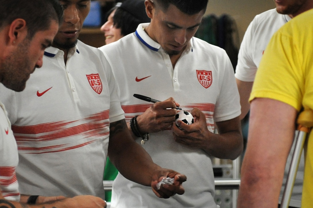 U.S. men's national soccer team members autograph soccer trinkets for wounded warrior at Walter Reed National Medical Center in Bethesda, Md., Sept. 3, 2015. DoD photo by Marvin Lynchard