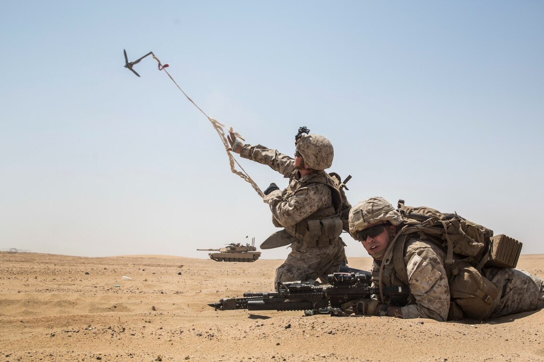 KUWAIT (Aug. 24, 2015) U.S. Marines Lance Cpl. Malachi Askland (left) and Cpl. Matthew Kobylarz clear a safe lane for their squad during mechanized squad attack training. Askland is an assualtman and Kobylarz is an assault team leader, both with Kilo Company, Battalion Landing Team 3rd Battalion, 1st Marine Regiment, 15th Marine Expeditionary Unit (MEU). The training focused on the squad’s ability to effectively utilize AAV-7 Amphibious Assault Vehicles, and M1A1 Abrams tanks to close with and destroy enemy targets. Elements of the 15th MEU are ashore in Kuwait for sustainment training to maintain and enhance the skills they developed during their pre-deployment training period. The 15th MEU is embarked with the Essex Amphibious Ready Group and deployed to maintain regional security in the U.S. 5th Fleet area of operations. (U.S. Marine Corps photo by Sgt. Emmanuel Ramos/Released)