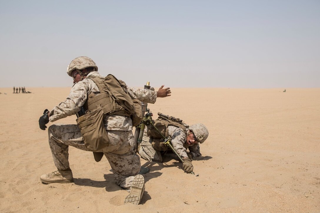 KUWAIT (Aug. 26, 2015) U.S. Marines Lance Cpl. Maurice Gardner, left, and Lance Cpl. Gary Gomez engage targets more than 500 meters away with an M224A1 60 mm mortar system during call-for-fire training. Gardner is an assistant gunner and Gomez is a gunner, both with Kilo Company, Battalion Landing Team 3rd Battalion, 1st Marine Regiment, 15th Marine Expeditionary Unit. During the training squad leaders sharpened their call-for-fire skills with mortarmen. Elements of the 15th MEU are ashore in Kuwait for sustainment training to maintain and enhance the skills they developed during their pre-deployment training period. The 15th MEU is embarked with the Essex Amphibious Ready Group and deployed to maintain regional security in the U.S. 5th Fleet area of operations. (U.S. Marine Corps photo by Sgt. Emmanuel Ramos/Released)