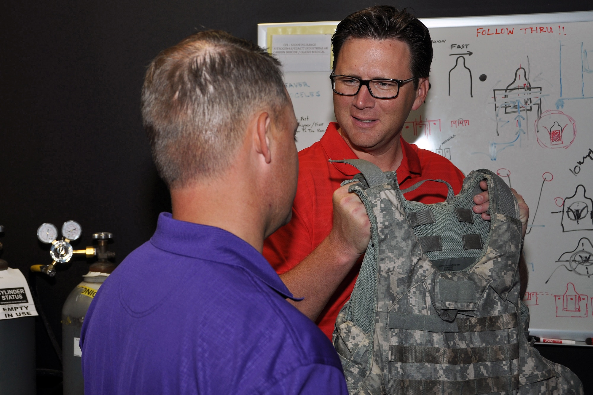 Brad Jurkovich, Senior Pastor for the First Baptist Church in Bossier City, La., (right) and Robbie Gatti, Pastor of Missions and Evangelism, feel the weight of the armor wounded warriors have to wear in the Firearms Training Simulator, or FATS, at the Center for the Intrepid in San Antonio, Texas, during a 307th Bomb Wing Civic Leader Tour, Sept. 1, 2015. The tour gave 29 Louisiana civic leaders the opportunity to get a closer look at the mission of the Air Force Reserve during the two-day trip from Barksdale to Joint Base San Antonio and Dyess Air Force Base in Texas. The trip included a refueling of the B-52 Stratofortress and B-1 Lancer; a C-5 Galaxy and B-1 static tour; a visit to the Center for the Intrepid for wounded warriors; and networking with other local community leaders. (U.S. Air Force photo by Master Sgt. Mary Hinson/Released)