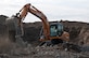 A member of a demolition team picks up remaining concrete from a demolished munition bunker Aug. 31, 2015, at Fairchild Air Force Base, Wash. The majority of the materials from the project are being recycled and reused, including rebar found in the concrete structures. (U.S. Air Force photo/Airman 1st Class Mackenzie Richardson)