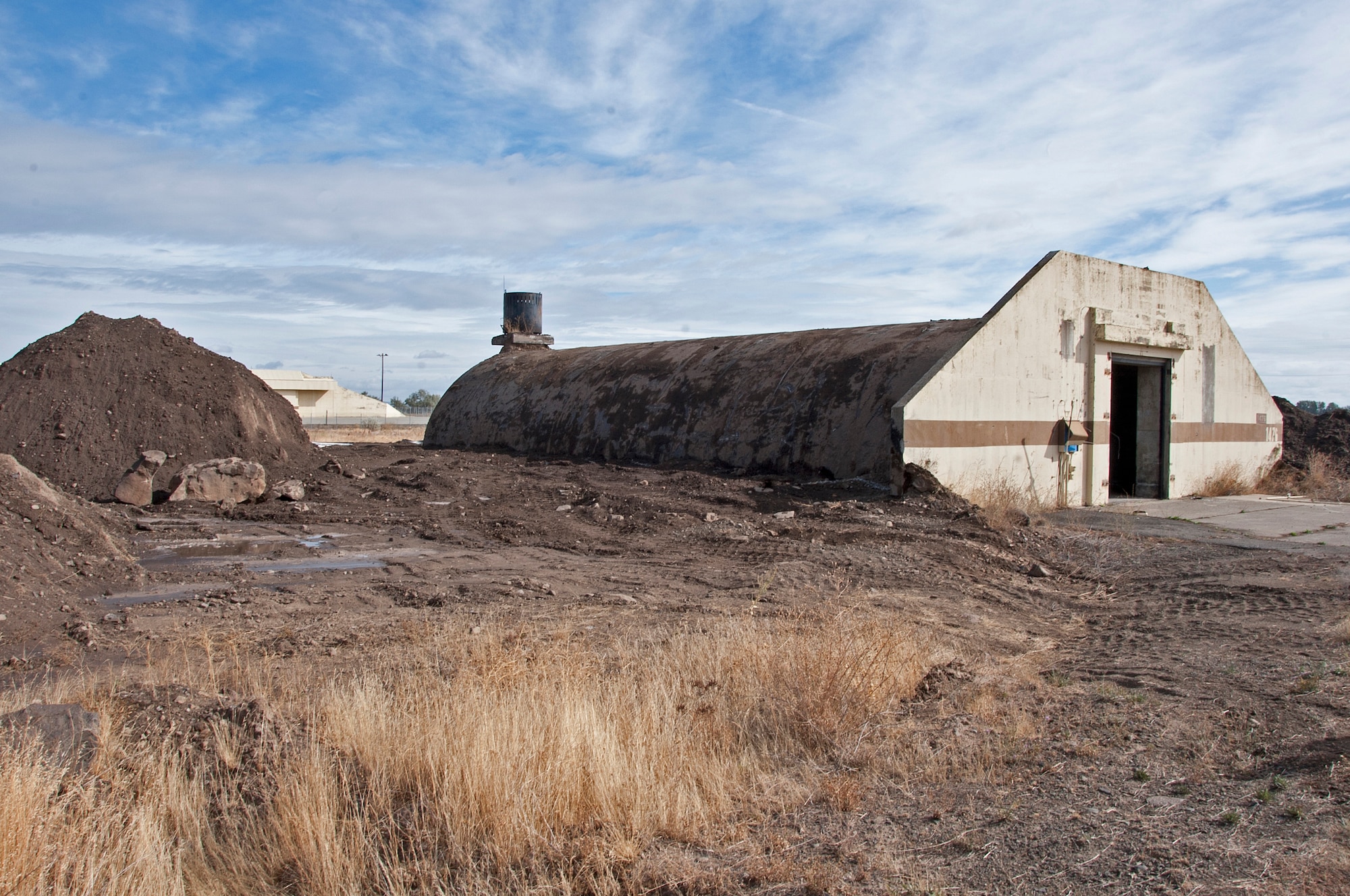 An original 1950s munition bunker is in the early stages of demolition Aug. 31, 2015, at Fairchild Air Force Base, Wash. The concrete bunkers were covered with many feet of soil, giving them a hill-like appearance, to ensure an accidental explosion would be buffered and not cause a chain reaction. (U.S. Air Force photo/Airman 1st Class Mackenzie Richardson)