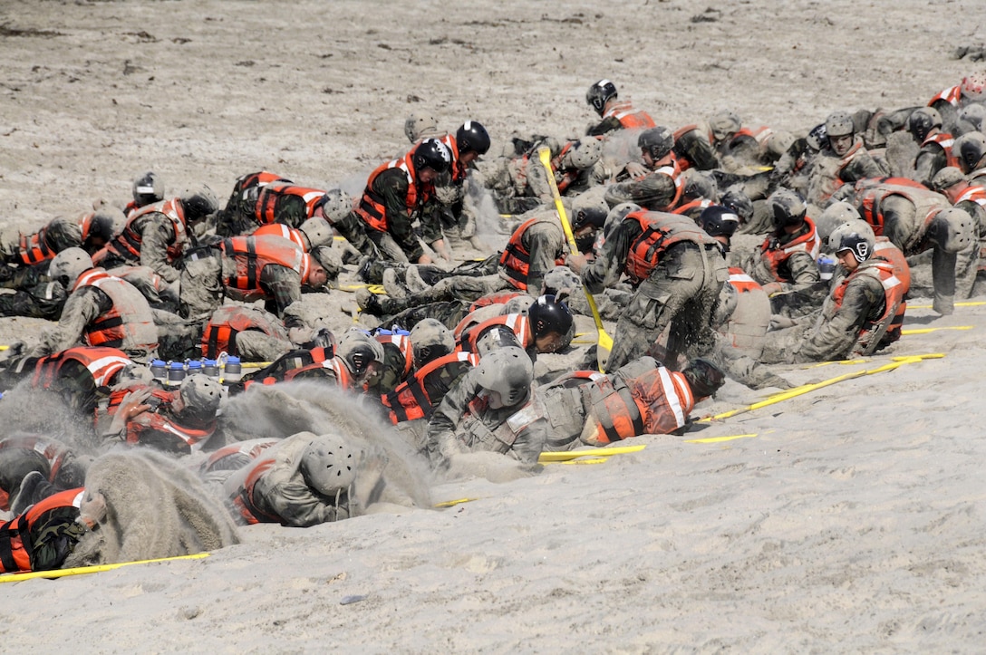 SEAL candidates for basic underwater demolition cover themselves in sand during surf passage on Naval Amphibious Base Coronado, Calif, Sept. 2, 2015. Surf passage is part of the first phase of SEAL training. U.S. Navy photo by Petty Officer 1st Class Michael Russell