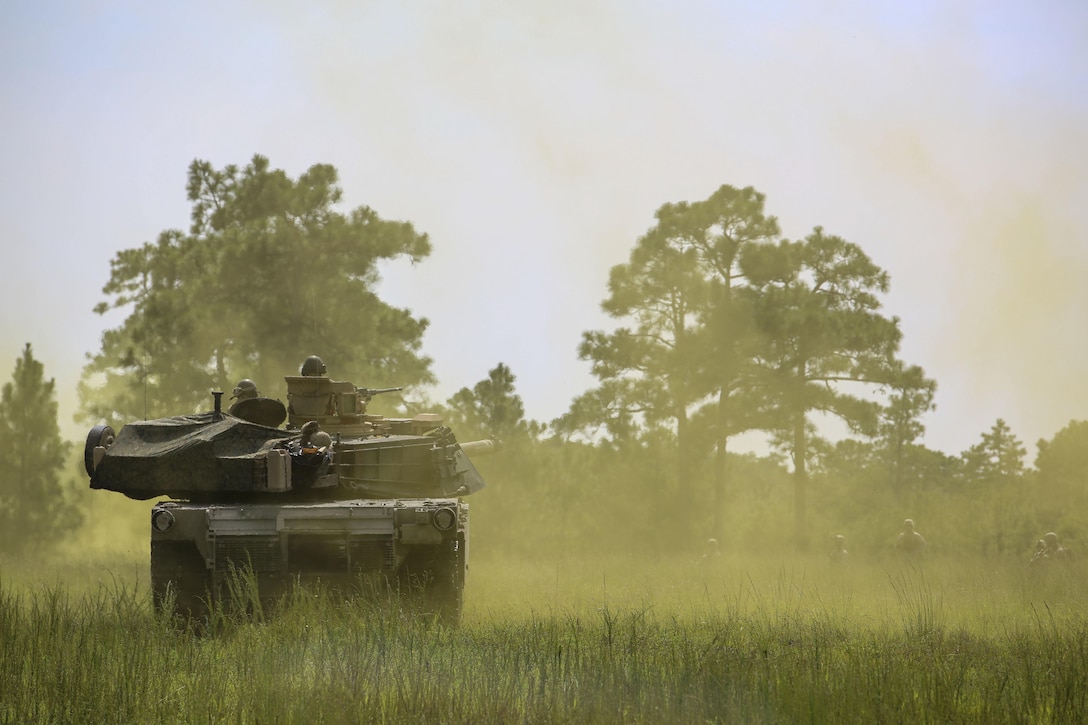 Marines with Alpha Company, 2nd Tank Battalion, roll through smoke to meet Marines with Golf Company, 2nd Battalion, 2nd Marine Regiment, during an integrated exercise at Landing Zone Dodo, Camp Lejeune, N.C., Sept. 2, 2015. The purpose of the exercise was to allow Marine infantry and tankers to work together. (U.S. Marine Corps photo by Cpl. Paul S. Martinez/Released)