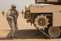 KUWAIT (Aug. 25, 2015) U.S. Marine Cpl. Nicholas Skidmore coordinates suppressive fire with tank crewmen during mechanized squad attack training. Skidmore is a squad leader with Kilo Company, Battalion Landing Team 3rd Battalion, 1st Marine Regiment, 15th Marine Expeditionary Unit. The training focused on the squad’s ability to work as a cohesive unit, while using AAV-7 Amphibious Assault Vehicles and M1A1 Abrams tanks, to effectively eliminate enemy targets. Elements of the 15th MEU are ashore in Kuwait for sustainment training to maintain and enhance the skills they developed during their pre-deployment training period.  The 15th MEU is embarked with the Essex Amphibious Ready Group and deployed to maintain regional security in the U.S. 5th Fleet area of operations. (U.S. Marine Corps photo by Sgt. Emmanuel Ramos/Released)