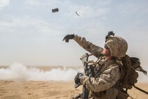 KUWAIT (Aug. 25, 2015) U.S. Marine Lance Cpl. Malachi Askland throws a smoke grenade to provide concealment for his squad during mechanized squad attack training. Askland is an assualtman with Kilo Company, Battalion Landing Team 3rd Battalion, 1st Marine Regiment, 15th Marine Expeditionary Unit. The training focused on the squad’s ability to work as a cohesive unit while using AAV-7 Amphibious Assault Vehicles and M1A1 Abrams tanks to effectively eliminate enemy targets. Elements of the 15th MEU are ashore in Kuwait for sustainment training to maintain and enhance the skills they developed during their pre-deployment training period.  The 15th MEU is embarked with the Essex Amphibious Ready Group and deployed to maintain regional security in the U.S. 5th Fleet area of operations. (U.S. Marine Corps photo by Sgt. Emmanuel Ramos/Released)
