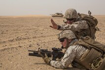 KUWAIT (Aug. 25, 2015) U.S. Marine Cpl. Nicholas Skidmore, top, coordinates fields of fire with Lance Cpl. Raul Fosselman during mechanized squad attack training. Skidmore is a squad leader and Fosselman is a team leader, both with Kilo Company, Battalion Landing Team 3rd Battalion, 1st Marine Regiment, 15th Marine Expeditionary Unit. The training focused on the squad’s ability to work as a cohesive unit while using AAV-7 Amphibious Assault Vehicles and M1A1 Abrams tanks to effectively eliminate enemy targets. Elements of the 15th MEU are ashore in Kuwait for sustainment training to maintain and enhance the skills they developed during their pre-deployment training period.  The 15th MEU is embarked with the Essex Amphibious Ready Group and deployed to maintain regional security in the U.S. 5th Fleet area of operations. (U.S. Marine Corps photo by Sgt. Emmanuel Ramos/Released)