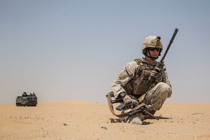 KUWAIT (Aug. 24, 2015) U.S. Marine Sgt. Daniel Davis coordinates rates of fire with team leaders during mechanized squad attack training. Davis is a squad leader with Kilo Company, Battalion Landing Team 3rd Battalion, 1st Marine Regiment, 15th Marine Expeditionary Unit (MEU). The training focused on the squad’s ability to effectively utilize AAV-7 Amphibious Assault Vehicles, and M1A1 Abrams tanks to close with and destroy enemy targets. Elements of the 15th MEU are ashore in Kuwait for sustainment training to maintain and enhance the skills they developed during their pre-deployment training period.  The 15th MEU is embarked with the Essex Amphibious Ready Group and deployed to maintain regional security in the U.S. 5th Fleet area of operations. (U.S. Marine Corps photo by Sgt. Emmanuel Ramos/Released)