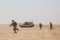 KUWAIT (Aug. 24, 2015) U.S. Marines with Kilo Company, Battalion Landing Team 3rd Battalion, 1st Marine Regiment, 15th Marine Expeditionary Unit (MEU), rush towards enemy targets during mechanized squad attack training. The training focused on the squad’s ability to effectively utilize AAV-7 Amphibious Assault Vehicles and M1A1 Abrams tanks to close with and destroy enemy targets. Elements of the 15th MEU are ashore in Kuwait for sustainment training to maintain and enhance the skills they developed during their pre-deployment training period.  The 15th MEU is embarked with the Essex Amphibious Ready Group and deployed to maintain regional security in the U.S. 5th Fleet area of operations. (U.S. Marine Corps photo by Sgt. Emmanuel Ramos/Released)