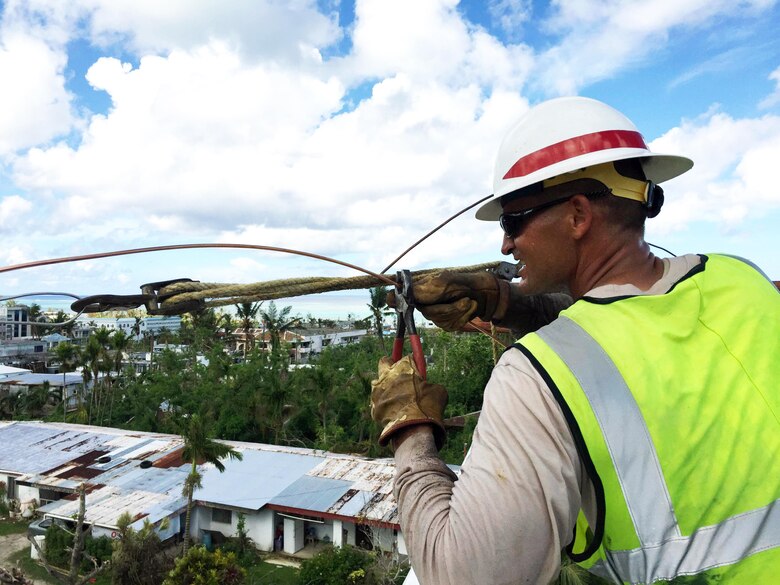 Delta Company's Cpl. David Schmidt repairs an electric line that powers water wells in the Gualo Rai area of Saipan.
