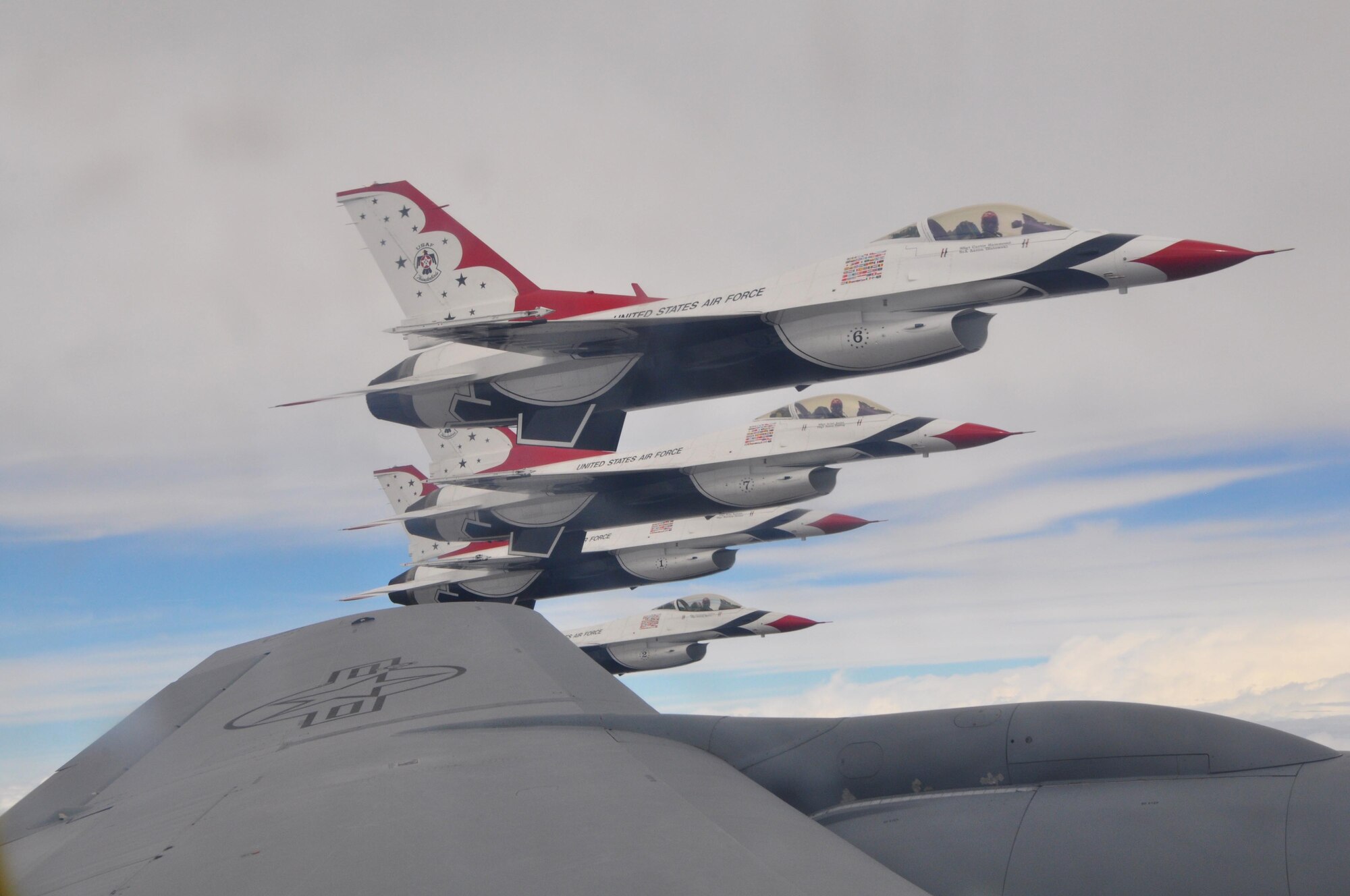 The U. S. Air Force Thunderbirds Air Demonstration Squadron, fly their F-16 Fighting Falcons in formation near the wing of a KC-135 Stratotanker from McConnell Air Force Base, Kan., Sept. 3, 2015.  The KC-135 provided cross-country air refueling support for the Thunderbirds.  This past season alone, the 931 ARG flew approximately 20 sorties with the team providing more than 700,000 gallons of fuel to help the team arrive on time to their scheduled shows.  (U.S. Air Force photo by Tech. Sgt. Abigail Klein)