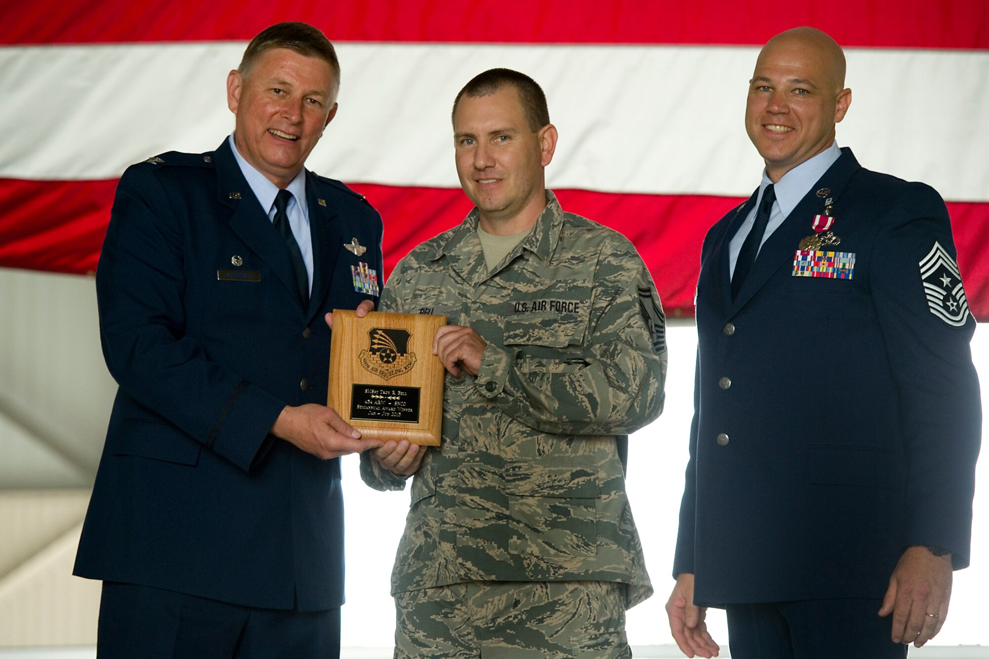Col. Doug Schwartz, 434th Air Refueling Wing commander, left, presents Senior Master Sgt. Troy Bell, 434th Maintenance Squadron flight chief, with a plaque after he was named top 434th ARW Senior noncommissioned officer for the first half of 2015 during a commander's call at Grissom Air Reserve Base, Ind., Aug. 9, 2015. Twice a year Grissom recognizes the best of the best with this award program. (U.S. Air Force photo/Senior Airman Jami Lancette)