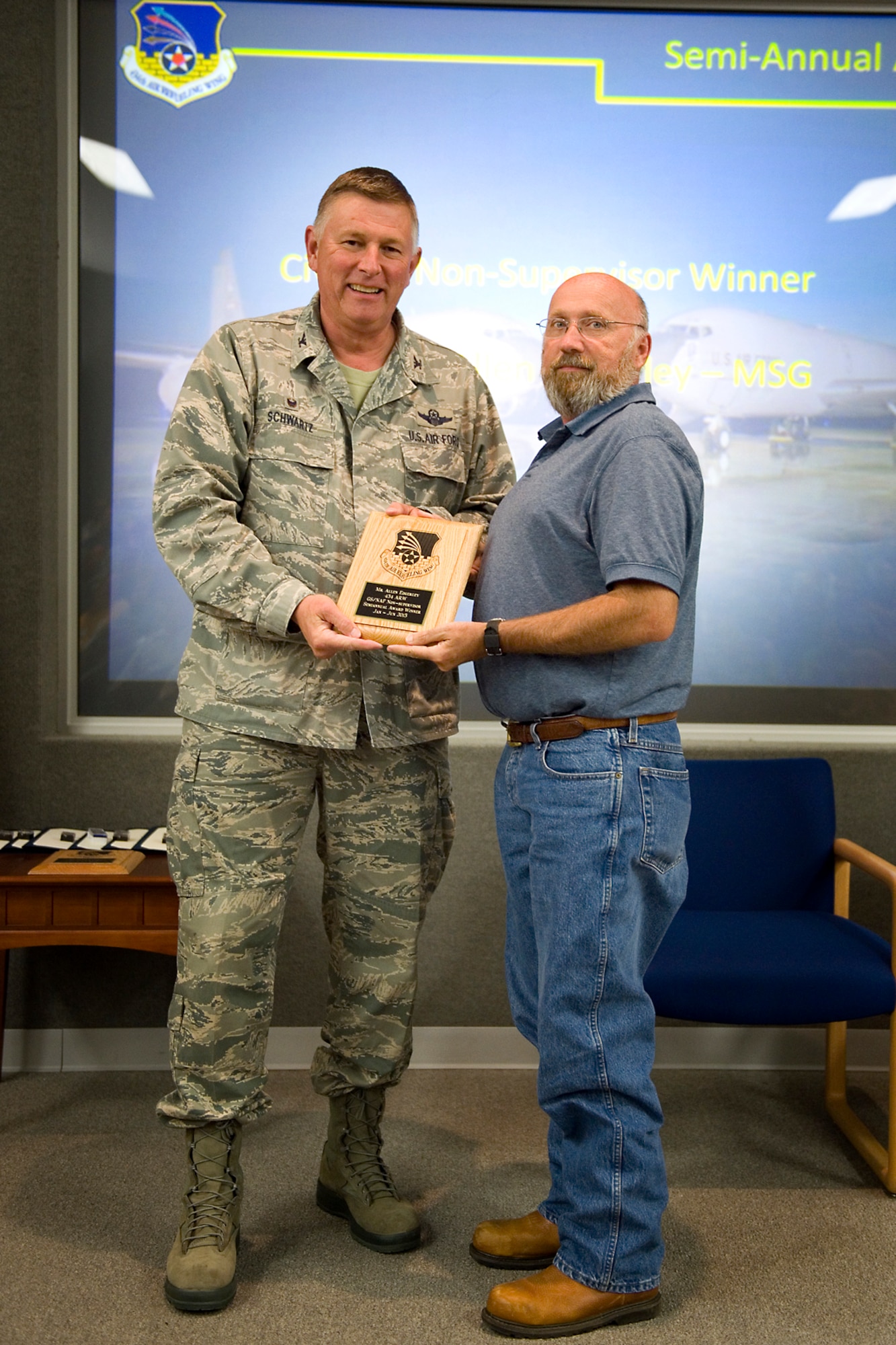 Col. Doug Schwartz, 434th Air Refueling Wing commander, left, presents Allen Edgerley, 434th Logistics Readiness Squadron supply and fuels quality assurance evaluator, with a plaque after he was named top 434th ARW civilian for the first half of 2015 during a commander's call at Grissom Air Reserve Base, Ind., Aug. 25, 2015. Twice a year Grissom recognizes the best of the best with this award program. (U.S. Air Force photo/Tech. Sgt. Benjamin Mota)