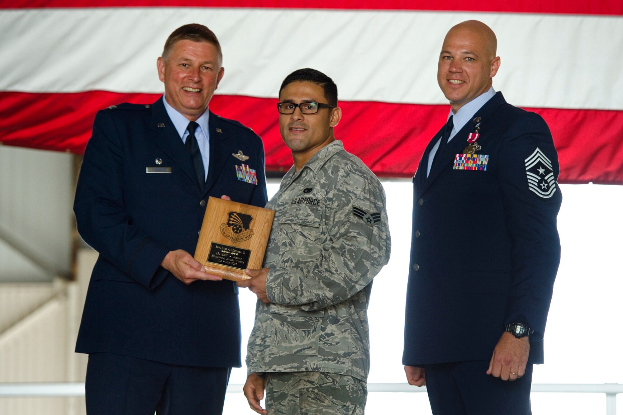 Col. Doug Schwartz, 434th Air Refueling Wing commander, left, presents Senior Airman Luis Mendoza, 434th Maintenance Squadron aerospace ground equipment specialist, with a plaque after he was named top 434th ARW Airman for the first half of 2015 during a commander's call at Grissom Air Reserve Base, Ind., Aug. 9, 2015. Twice a year Grissom recognizes the best of the best with this award program. (U.S. Air Force photo/Senior Airman Jami Lancette)