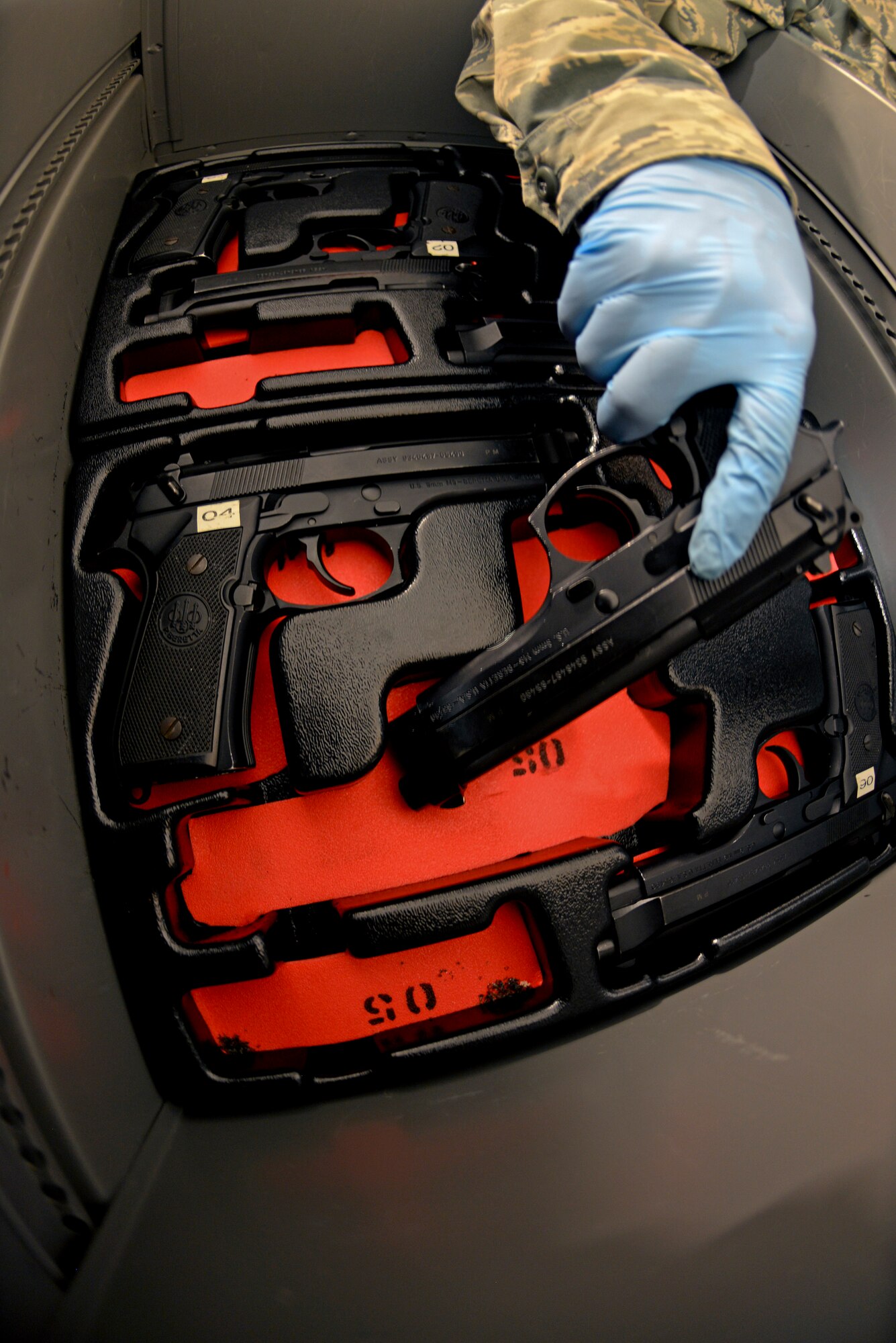 U.S. Air Force Senior Airman Alexandria Delguidice, 100th Operations Support Squadron Aircraft Flight Equipment journeyman, places an M-9 pistol in a secure locker Sept. 3, 2015, on RAF Mildenhall, England. Once the firearms are serviced and up to date, they can be issued to aircrew for missions over hostile areas. (U.S. Air Force photo by Staff Sgt. Micaiah Anthony/Released)
