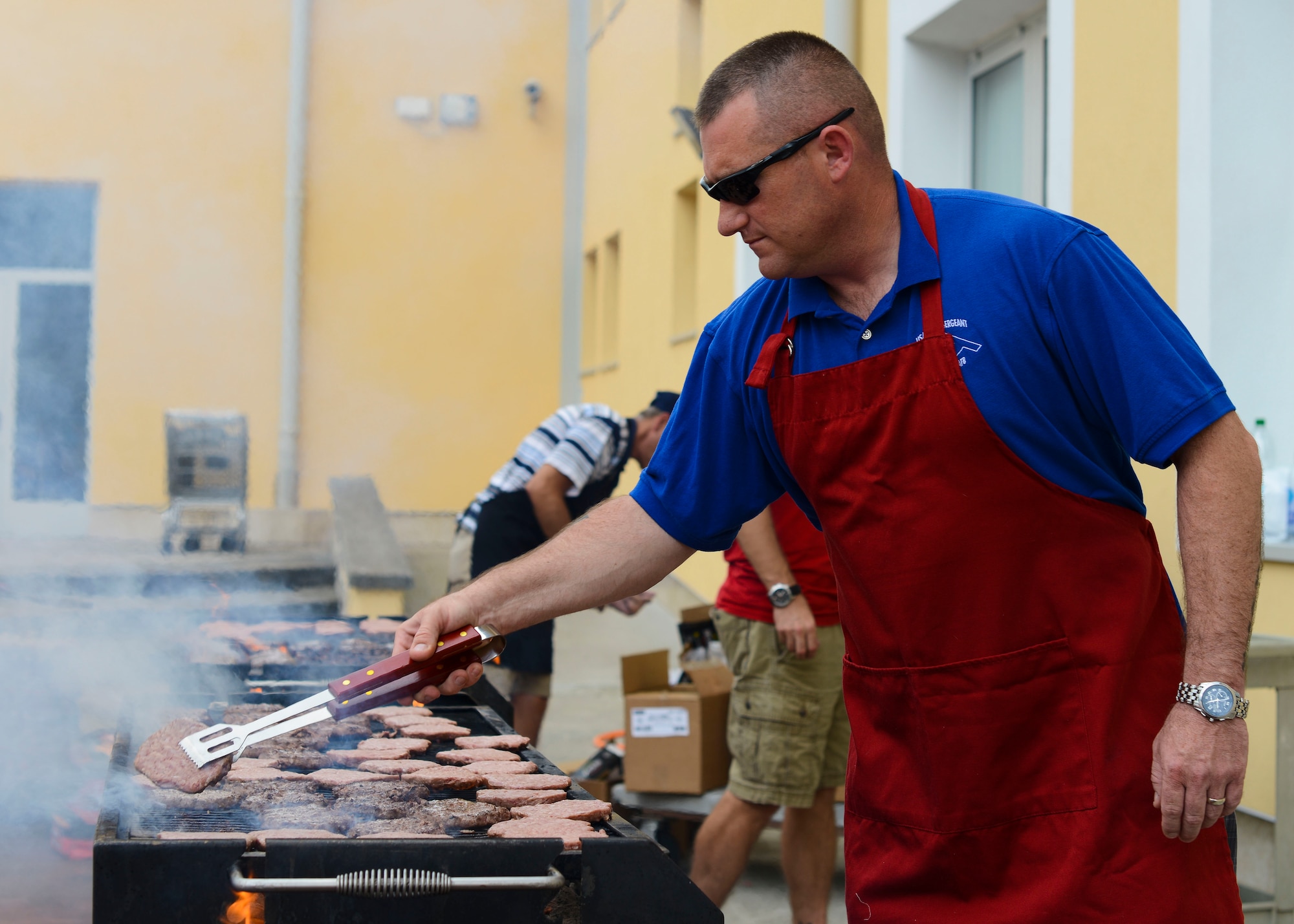 U.S. Air Force Master Sgt. Donnie Gray, 31st Force Support Squadron first sergeant, grills burgers during the Back-2-School Bash, Sept. 3, 2015, at Aviano Air Base, Italy. The 31st Mission Support Group, First Sergeant’s Association and School Liaison Office sponsored the event with the help of volunteer Wyvern Warriors. (U.S. Air Force photo by Senior Airman Austin Harvill/Released)