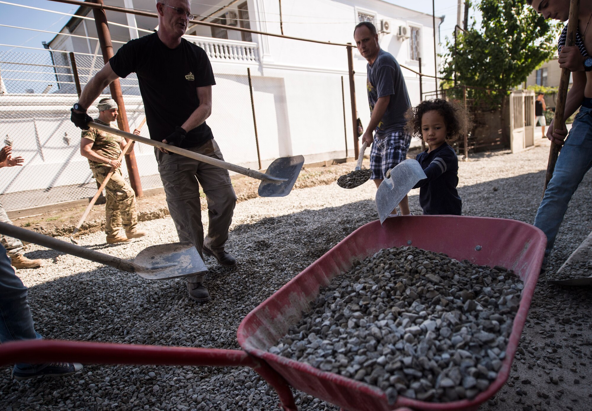 Students, teachers, neighbors and U.S. Air Force and Georgian army engineers pitch in to help spread gravel for Gori Public School No. 4’s new driveway in Gori, Georgia Aug. 30, 2015. The new driveway and entire renovation of the school is part of a Humanitarian and Civic Assistance project, a U.S. European Command program that is designed to provide assistance to the Georgian populace and help military members and civilians hone building and construction skills and trades. Humanitarian and Civic Assistance projects enhance operational readiness of military personnel while providing mutual support to the host nation's population. (U.S. Air Force photo/Staff Sgt. Sara Keller)