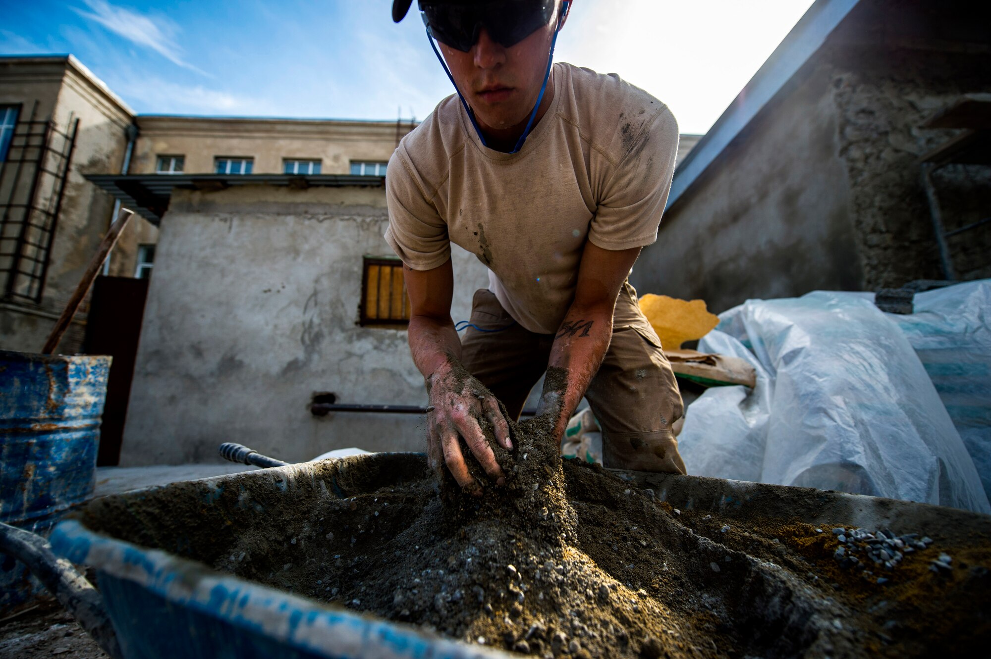 U.S. Air Force Airman 1st Class Cole Kasten, 52nd Civil Engineer Squadron pavement and heavy equipment operator, mixes cement for a ramp at Public School No. 4 in Gori, Georgia, Aug. 28, 2015. Kasten and a team of U.S. Air Force Airmen built the ramp to give disabled students at the school safe access into the gymnasium. Humanitarian and Civic Assistance projects enhance operational readiness of military personnel while providing mutual support to the host nation's population. (U.S. Air Force photo/Staff Sgt. Sara Keller)