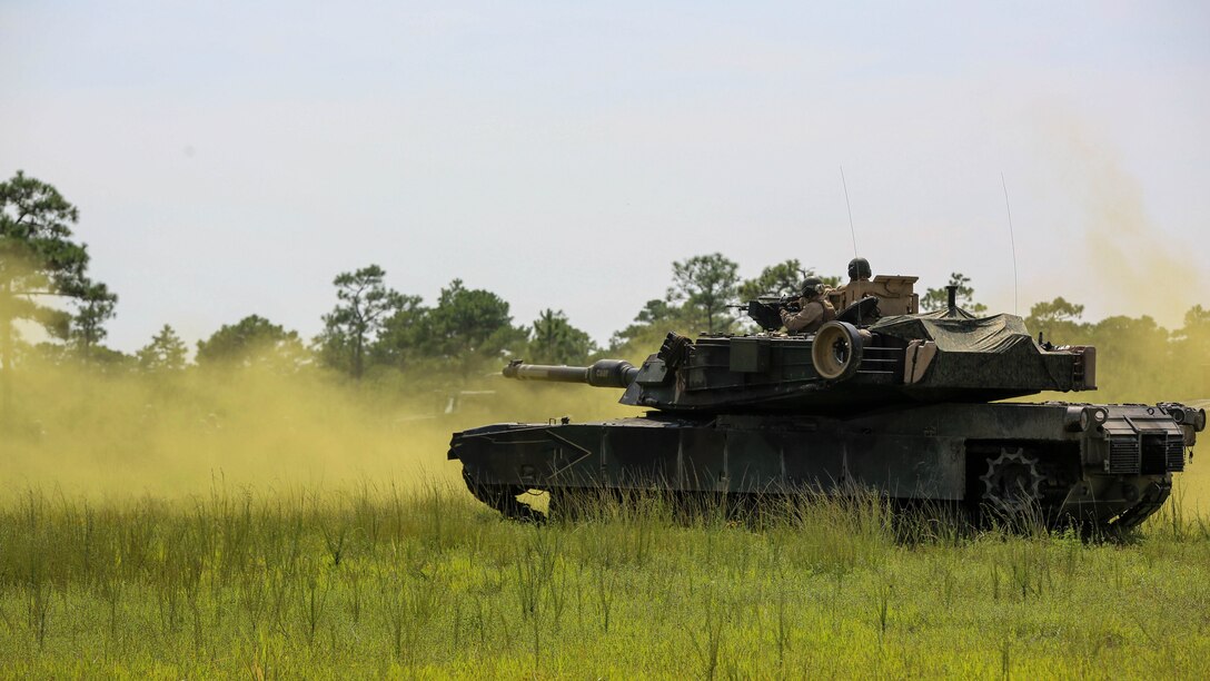 Marines with Alpha Company, 2nd Tank Battalion, roll through smoke to meet Marines with Golf Company, 2nd Battalion, 2nd Marine Regiment, during an integrated exercise at Landing Zone Dodo, Camp Lejeune, N.C., Sept. 2, 2015. The purpose of the exercise was to allow Marine infantry and tankers to work together.
