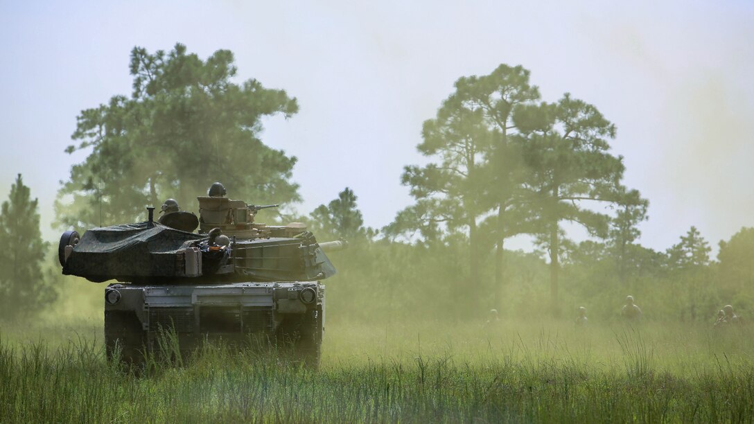 Marines with Alpha Company, 2nd Tank Battalion, roll through smoke to meet Marines with Golf Company, 2nd Battalion, 2nd Marine Regiment, during an integrated exercise at Landing Zone Dodo, Camp Lejeune, N.C., Sept. 2, 2015. The purpose of the exercise was to allow Marine infantry and tankers to work together. 