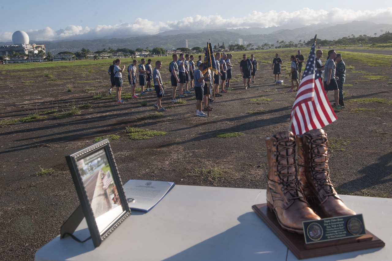 A U.S. Navy running team stretches together after finishing the Fisher House Hero and Remembrance Run, Walk or Roll event Sept. 5, 2015, at Joint Base Pearl Harbor-Hickam, Hawaii. More than 7,000 combat boots were placed along the 8K route, each adorned with a photo of a service member who gave their life while serving their country after 9/11. U.S. Air Force photo by Staff Sgt. Christopher Hubenthal