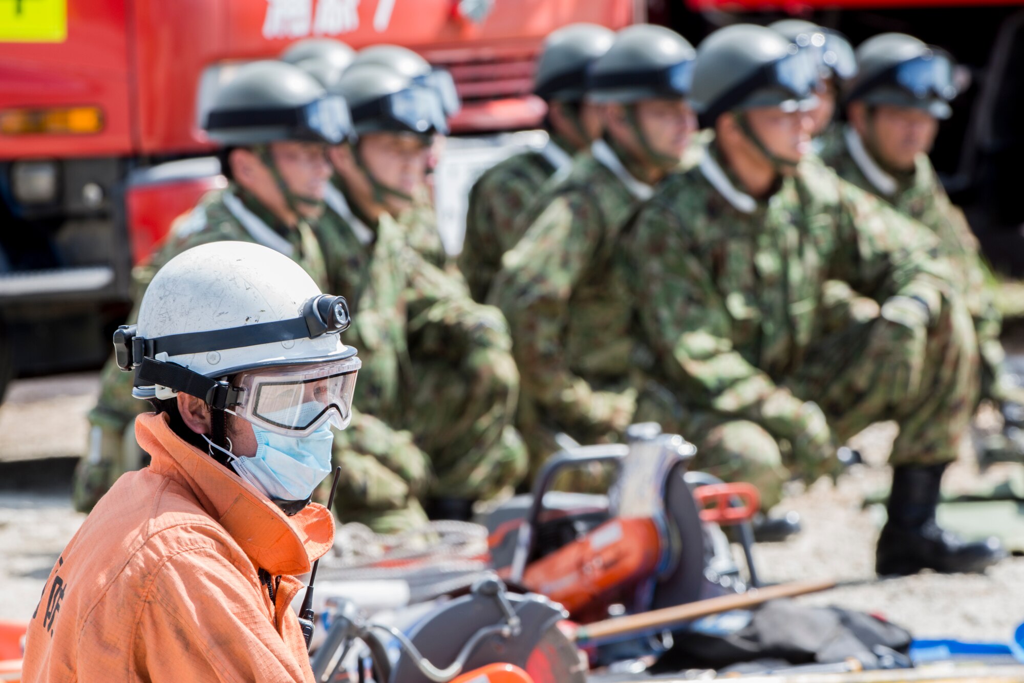 An Okinawa emergency responder waits alongside Japan Ground Self-Defense Force members before clearing rubble to search for simulated victims during an annual Okinawa Prefectural Government bilateral disaster response exercise at Atta Port, Japan, Sept. 5, 2015. The scenario centered on the evacuation and rescue of Okinawa inhabitants following a deadly tsunami hitting the island’s eastern coast. A total of 82 separate entities from the U.S. military, Japan Self-Defense Force and local emergency responders worked together to ensure the success of the exercise. (U.S. Air Force photo by Staff Sgt. Maeson L. Elleman)