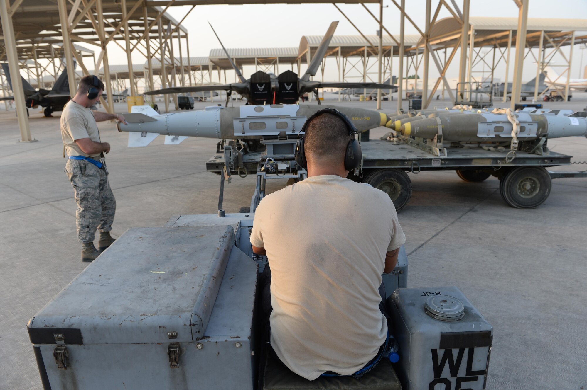 380th Expeditionary Maintenance Airmen prepare to load munitions on an F-22 Raptor at an undisclosed location in Southwest Asia, August 30, 2015. The F-22’s combination of sensor capability, integrated avionics, situational awareness, and weapons provides first-kill opportunity against threats. (U.S. Air Force photo illustration/ Staff Sgt. Sandra Welch)
