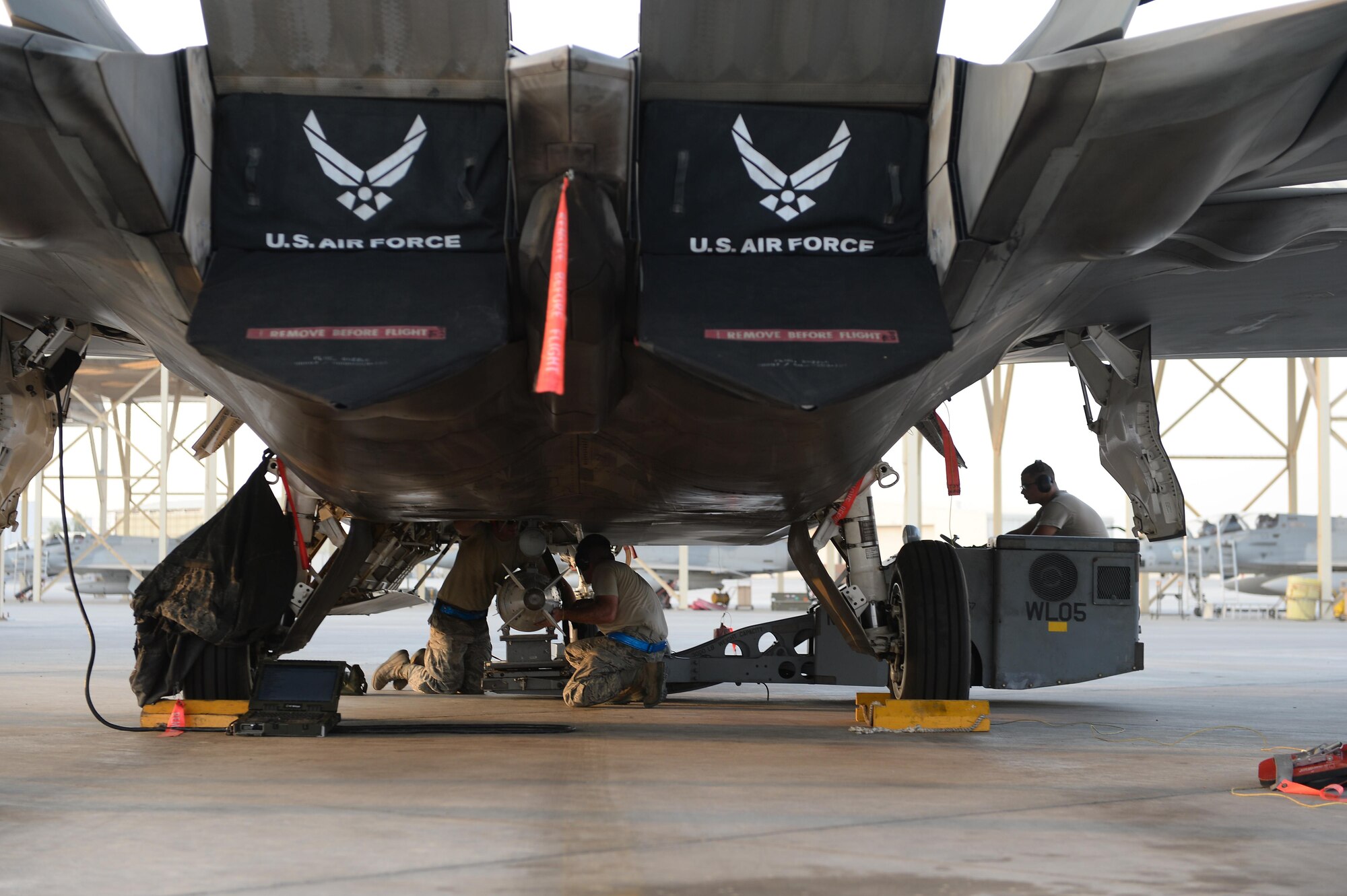 380th Expeditionary Maintenance Airmen prepare to load munitions on an F-22 Raptor at an undisclosed location in Southwest Asia, August 30, 2015. The F-22’s combination of sensor capability, integrated avionics, situational awareness, and weapons provides first-kill opportunity against threats. (U.S. Air Force photo illustration/ Staff Sgt. Sandra Welch)