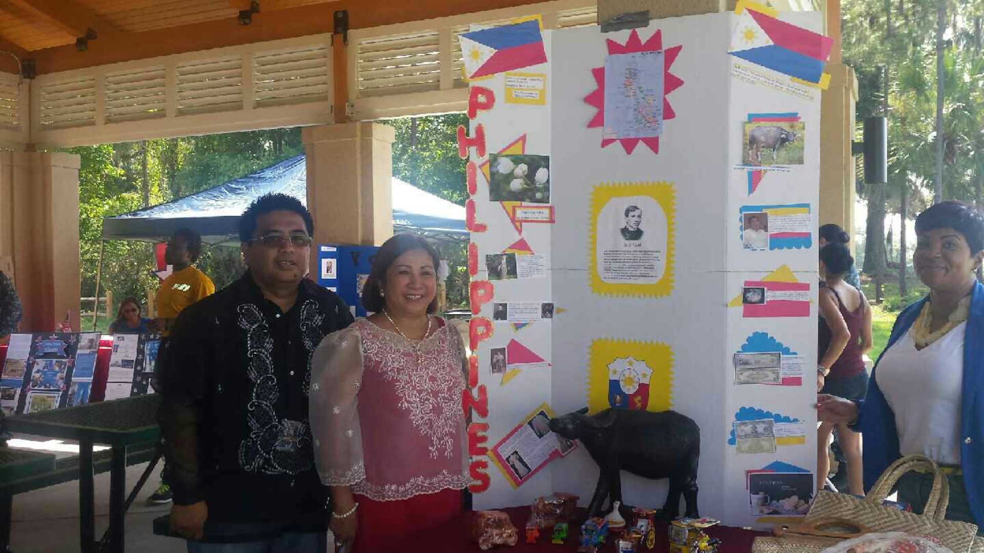 On July 22, 2015 Employees at Defense Logistics Agency Aviation at Jacksonville, Florida participate in the Naval Air Station (NAS) Jacksonville's “Multicultural Fun Day" at the base's marina pavilion. (Left to right) Lead Customer Support Specialist Noel Magsakay, Sustainment Specialist Melinda Caliolio, and Administrative Support Assistant (contractor) Denise Cummings, all from DLA Aviation at Jacksonville, attend a display highlighting the Philippines and Filipino culture. 