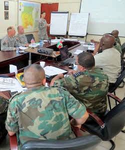 U.S. Army Capt. Jodi Gilberti, operations officer, South Dakota Army National Guard, briefs leadership from Suriname’s Army, Navy, Air Force, Military Police, Special Troops and the National Coordination Center for Disaster Relief during a subject-matter expert exchange focusing on disaster response best practices in Paramaribo, Suriname, Aug. 26, 2015. South Dakota and Suriname, in coordination with U.S. Southern Command, established a successful security cooperation relationship in 2006 under the National Guard Bureau’s State Partnership Program.