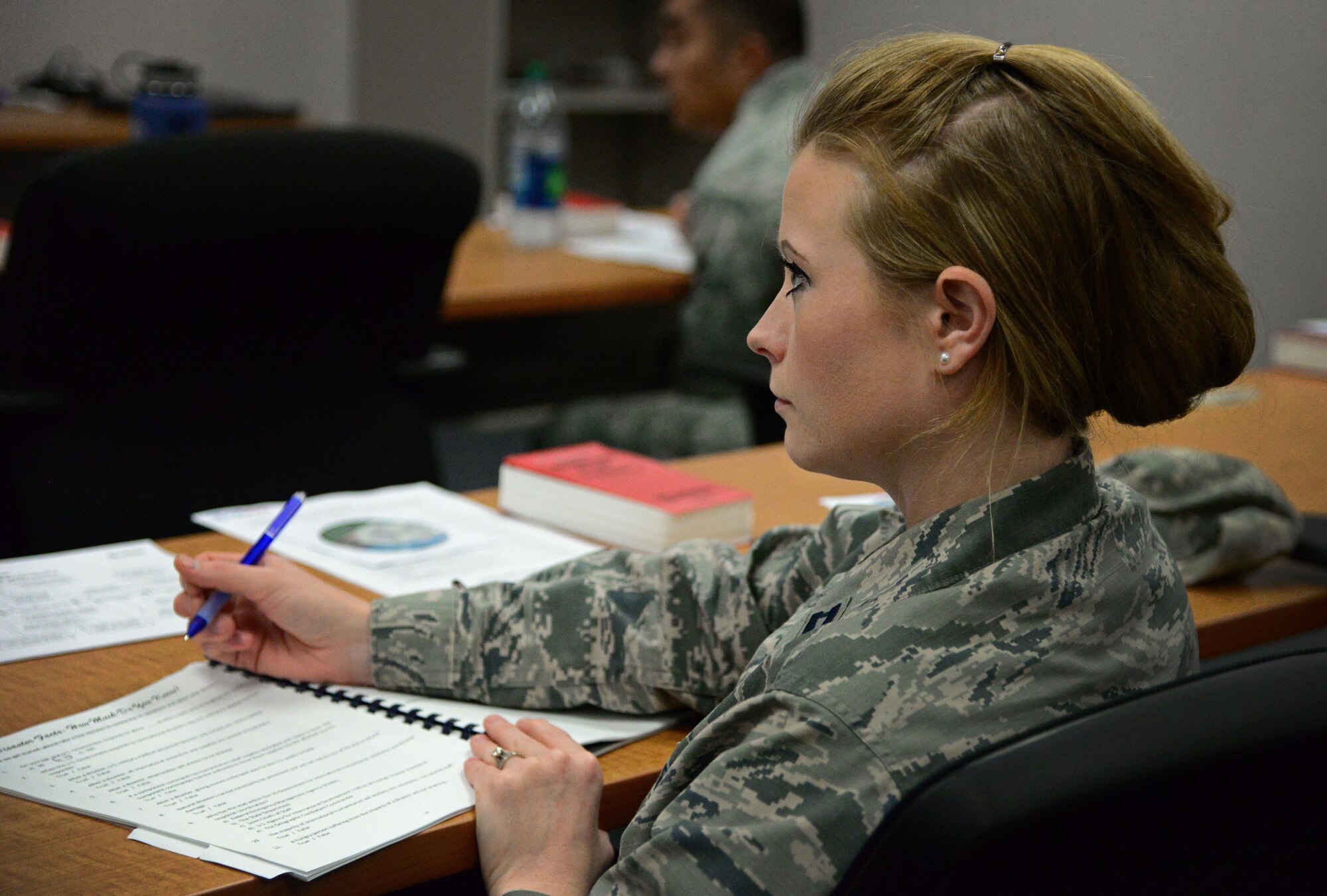 An Air Commando, participating as a student in a Joint Humanitarian Operations Course, takes notes during lecture Aug. 26, 2015 at Cannon Air Force Base, N.M. The class, led by the United States Agency for International Development, Office of U.S. Foreign Disaster Assistance, was able to incorporate and apply lecture lessons to past real-world disaster and humanitarian aid scenarios. (U.S. Air Force photo/Staff Sgt. Alexx Mercer) 