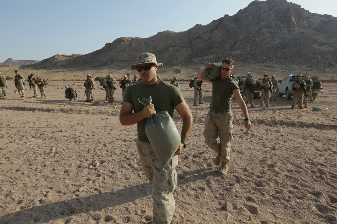 Southwest Asia (Aug. 18, 2015)  U.S. Marine Cpl. William Bowling, left, and Lance Cpl. James White carry sand bags during a range setup. Bowling is a radio operator and White is a rifleman with India Company, Battalion Landing Team 3rd Battalion, 1st Marine Regiment, 15th Marine Expeditionary Unit. The 15th MEU is deployed throughout Southwest Asia to maintain regional security in the U.S. 5th Fleet area of operations.  The 15th MEU provides flexible, responsive options across the range of military operations to support regional security in the U.S. 5th Fleet AOR. (U.S. Marine Corps photo by Sgt. Jamean Berry/Released)