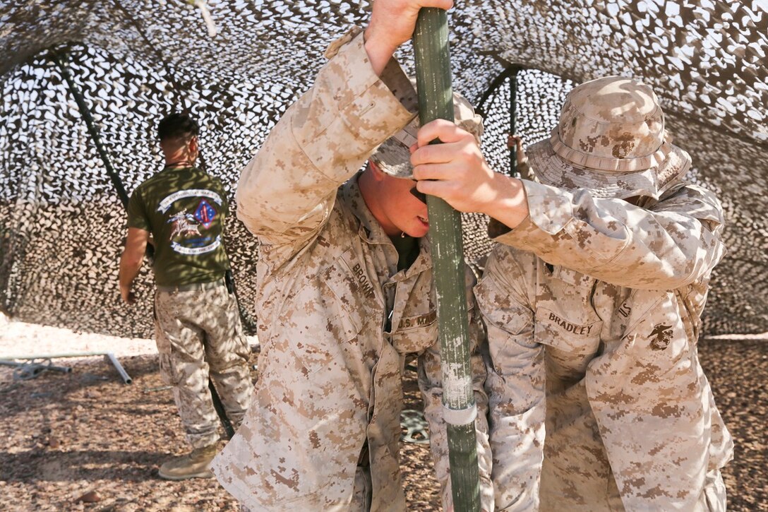 SOUTHWEST ASIA (Aug. 24, 2015)  U.S. Marine Lance Cpl. Nickolaus Brown, left, and Cpl. Sean Bradley, right, set up a camouflage net during a bi-lateral training exercise. Brown and Bradley are riflemen with India Company, Battalion Landing Team 3rd Battalion, 1st Marine Regiment, 15th Marine Expeditionary Unit.  The 15th MEU, embarked aboard the ships of the Essex Amphibious Ready Group, is a forward-deployed, flexible sea-based MAGTF capable of engaging with regional partners and maintaining regional security. (U.S. Marine Corps photo by Sgt. Jamean Berry/Released)