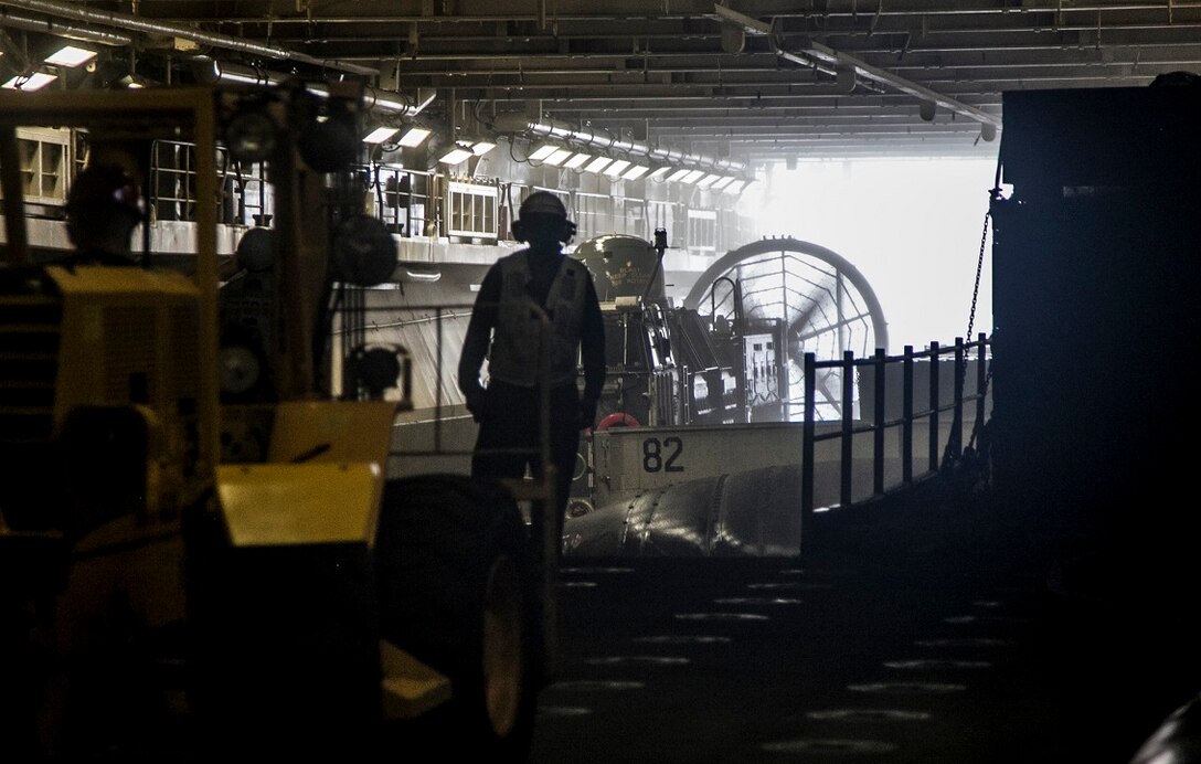 ARABIAN GULF (Sept. 3, 2015)  A U.S. Sailor with the Essex Amphibious Ready Group assists with escorting Landing Craft, Air Cushion 82in the well deck aboard the amphibious assault ship USS Essex (LHD 2). The 15th MEU is embarked aboard the Essex Amphibious Ready Group and deployed to maintain regional security in the U.S. 5th Fleet area of operations. (U.S. Marine Corps photo by Cpl. Elize McKelvey/Released)