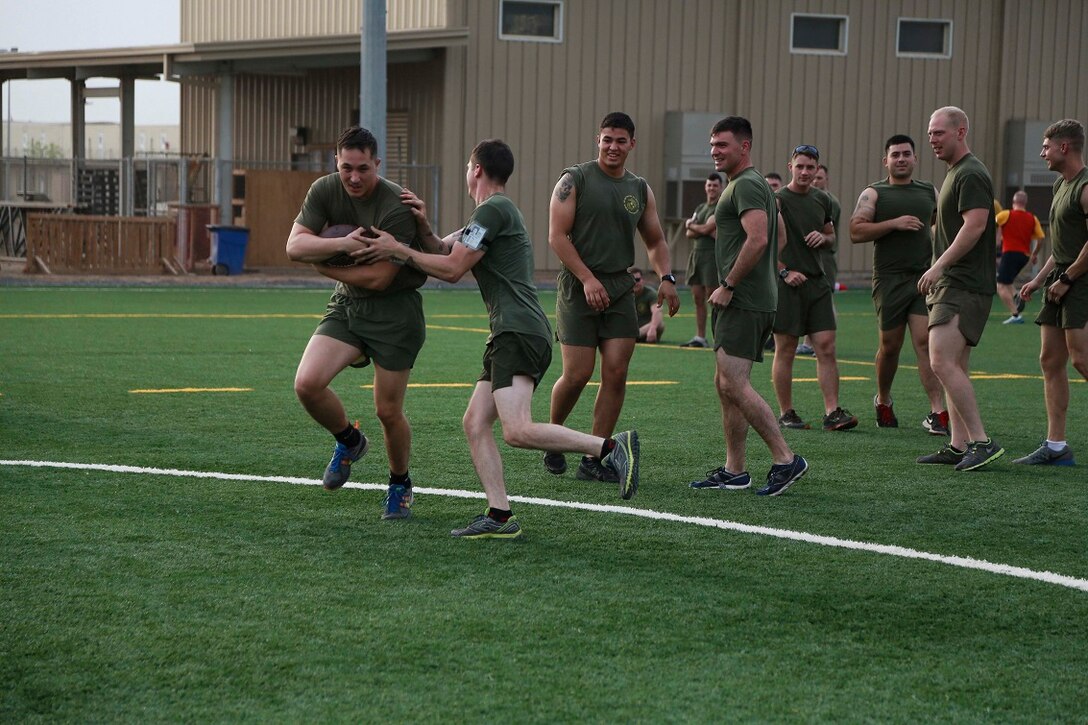 CAMP LEMONNIER, Djibouti (Sept. 4, 2015) U.S. Marine Cpl. Lucas Oisten, left, runs with the football for a touch-down during unit physical training. Oisten is radio operator with Weapons Company, Battalion Landing Team 3rd Battalion, 1st Marine Regiment, 15th Marine Expeditionary Unit.  The Marines used the football game to build camaraderie, acclimatize to Djibouti’s temperatures, and stay fit. Elements of the 15th MEU are preparing to conduct bilateral training with the 5th Overseas Combined Arms Regiment (RIAOM) in Djibouti in order to improve interoperability between the MEU and the French military. (U.S. Marine Corps photo by Sgt. Steve H. Lopez/Released)