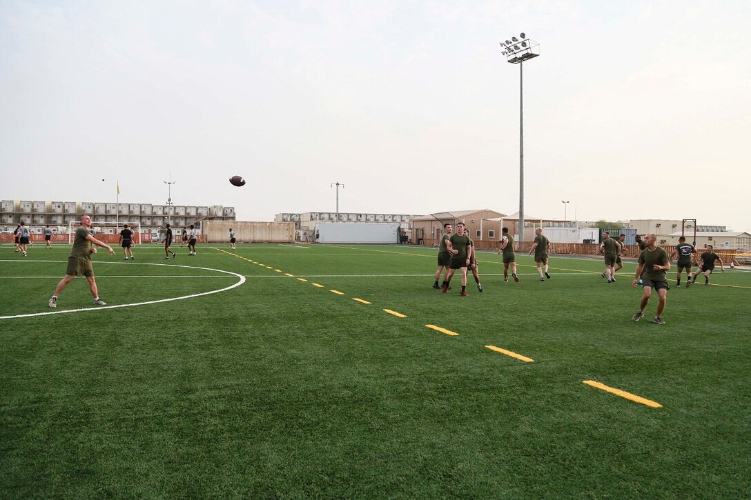 CAMP LEMONNIER, Djibouti (Sept. 4, 2015) U.S. Marine Sgt. Patrick Allen, left, throws the football to his team during unit physical training. Allen is a section leader with Weapons Company, Battalion Landing Team 3rd Battalion, 1st Marine Regiment, 15th Marine Expeditionary Unit. The Marines used the football game to build camaraderie, acclimatize to Djibouti’s temperatures, and stay fit. Elements of the 15th MEU are preparing to conduct bilateral training with the 5th Overseas Combined Arms Regiment (RIAOM) in Djibouti in order to improve interoperability between the MEU and the French military. (U.S. Marine Corps photo by Sgt. Steve H. Lopez/Released)