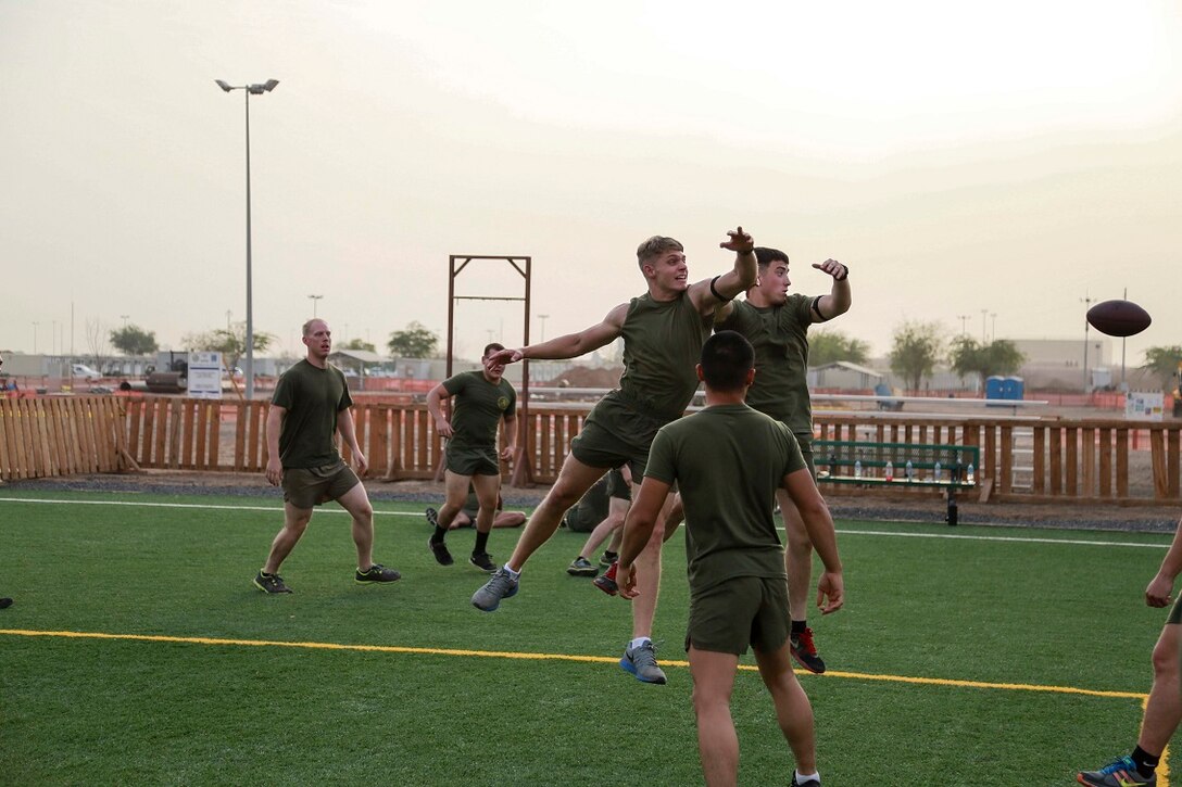 CAMP LEMONNIER, Djibouti (Sept. 4, 2015) U.S. Marine Lance Cpl. Jedediah Vance, left, and Cpl.  Jake Kelley jump up for a catch during unit physical training. Kelley is a vehicle commander and Vance is a gunner with Weapons Company, Battalion Landing Team 3rd Battalion, 1st Marine Regiment, 15th Marine Expeditionary Unit. The Marines used the football game to build camaraderie, acclimatize to Djibouti’s temperatures, and stay fit. Elements of the 15th MEU are preparing to conduct bilateral training with the 5th Overseas Combined Arms Regiment (RIAOM) in Djibouti in order to improve interoperability between the MEU and the French military. (U.S. Marine Corps photo by Sgt. Steve H. Lopez/Released)