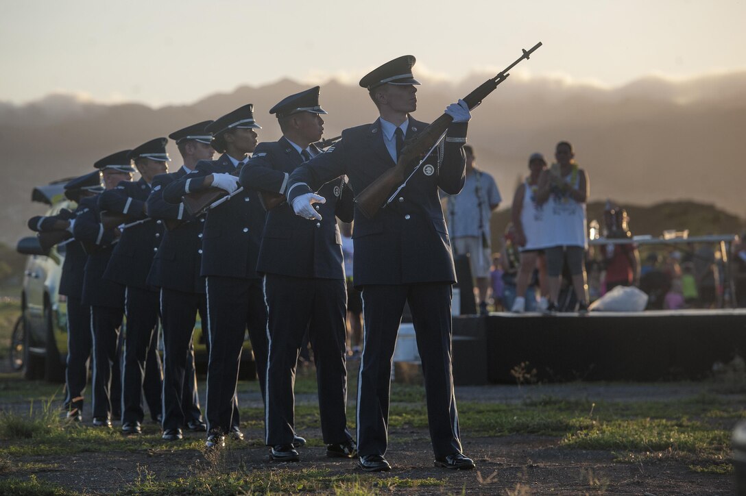 U.S. Air Force honor guard members render honors during the Fisher House Hero and Remembrance Run, Walk or Roll event on Joint Base Pearl Harbor-Hickam on Oahu, Hawaii, Sept. 5, 2015. More than 7,000 combat boots were placed along the 8-kilometer route, each adorned with a photo of a service member who gave their life while serving their country after 9/11. U.S. Air Force photo by Staff Sgt. Christopher Hubenthal