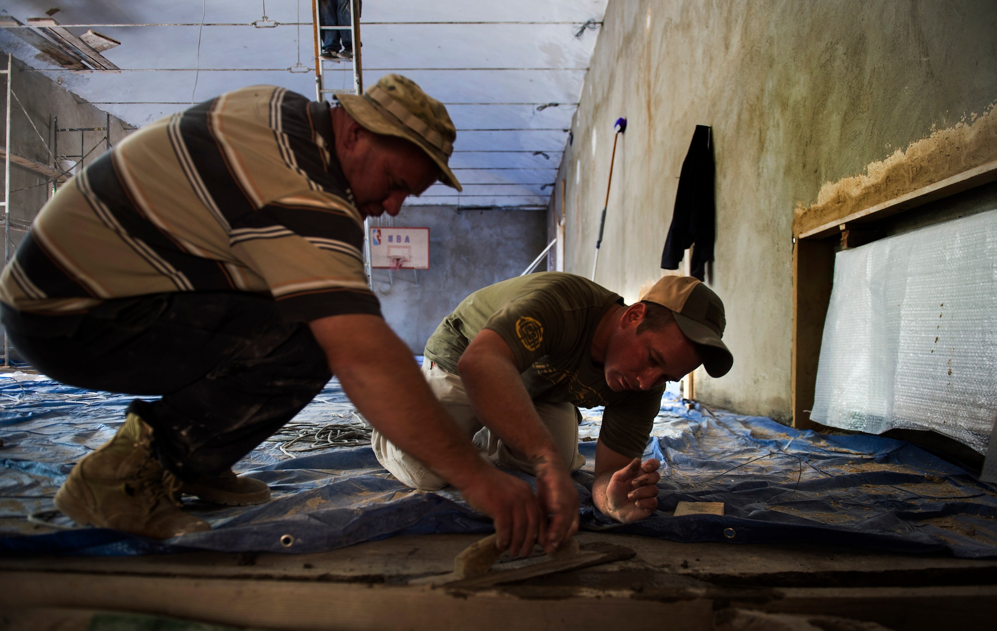 Staff Sgt. David Dengate, a 435th Construction and Training Squadron pavement and equipment operator, works with a Georgian army engineer to help fill in concrete in the entrance to the gymnasium of Public School No. 4 in Gori, Georgia, Aug. 27, 2015. Air Force and Georgian army engineers sometimes worked 16-hour days during a 30-day school renovation project that will help the children of Gori. Humanitarian and civic assistance projects enhance operational readiness of military personnel while providing mutual support to the host nation's population. (U.S. Air Force photo/Staff Sgt. Sara Keller) 