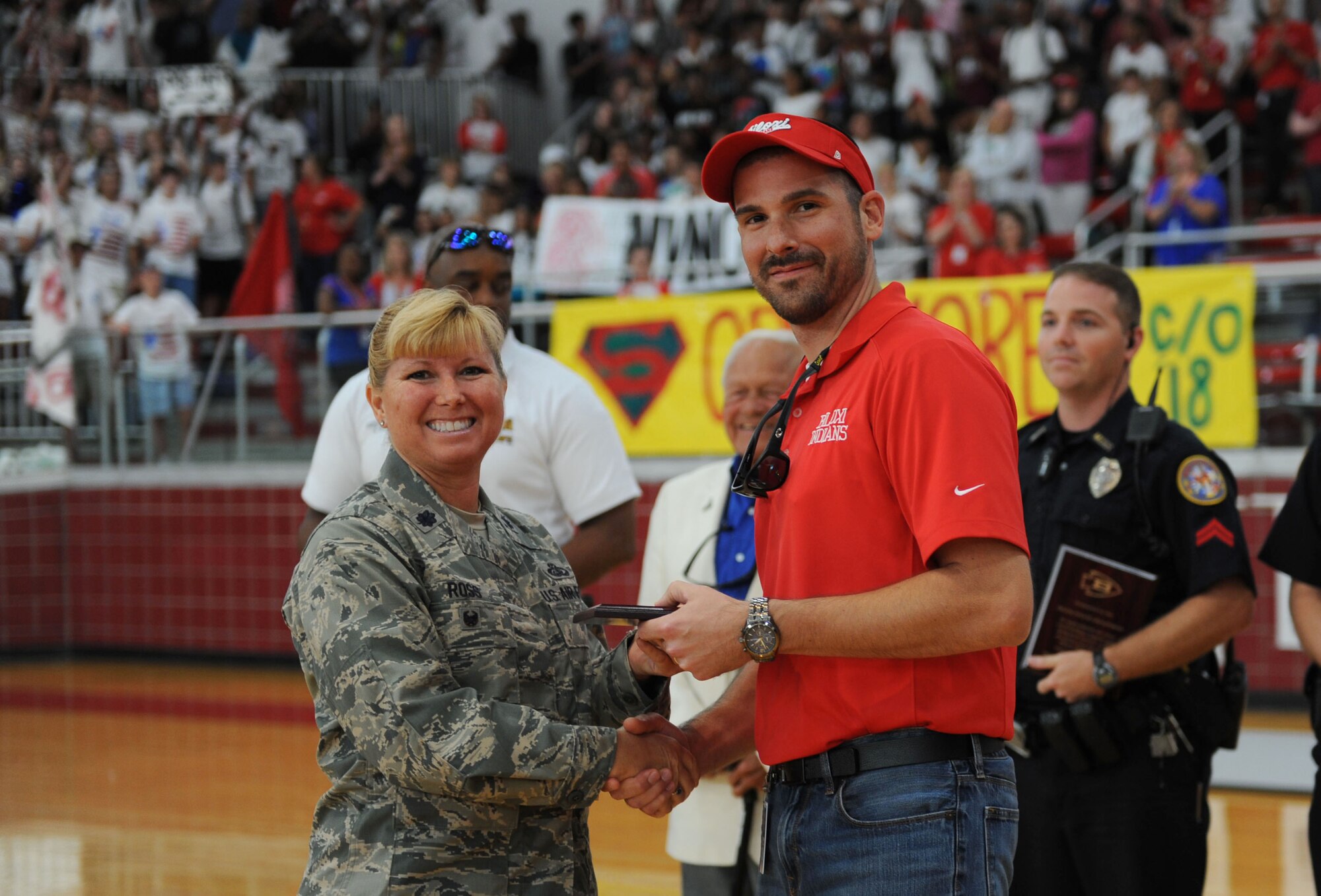 Lt. Col. Betsy Ross, 81st Mission Support Group deputy commander, accepts a plaque on behalf of Keesler Air Force Base from Marcus Boudreaux, Biloxi High School principal, during a Biloxi High School pep rally Sept. 4, 2015, Biloxi, Miss. The event was held to honor local heroes such as military members, police officers and firefighters.  (U.S. Air Force photo by Kemberly Groue)