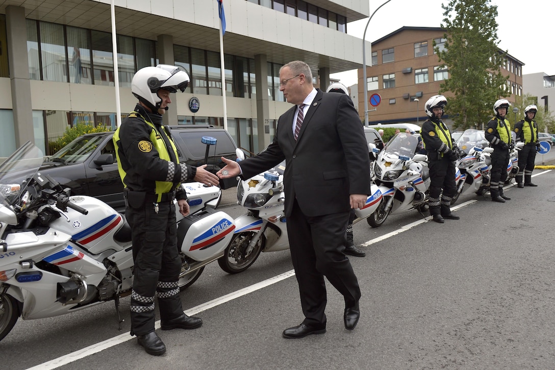 U.S. Deputy Defense Secretary Bob Work thanks and offers coins to the motorcycle patrol members who escorted his motorcade as he departs the Ministry of Foreign Affairs in Reykjavik, Iceland, Sept. 7, 2015. DoD photo by Glenn Fawcett