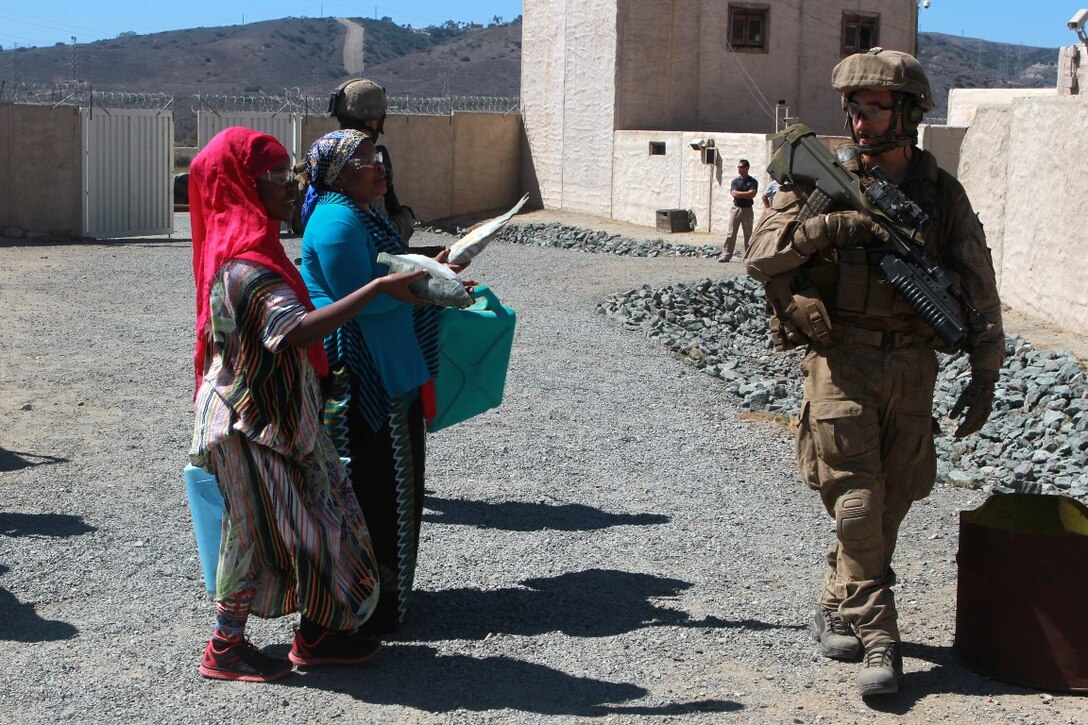 A soldier with 1st Royal New Zealand Infantry Regiment stays attentive as he passes by role players in the Infantry Immersion Trainer during Exercise Dawn Blitz at Marine Corps Base Camp Pendleton, Calif., Sept. 7, 2015. The IIT is a training facility that provides individuals with stressful scenarios they might encounter during combat operations in urban areas. Dawn Blitz is a multinational amphibious exercise that promotes interoperability between the U.S. Navy, Marine Corps and coalition partners. (U.S. Marine Corps photo taken by Sgt. Joseph Scanlan)
