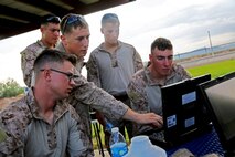 Sergeant Ethaniel Rock, a reconnaissance man with 1st Reconnaissance Battalion, 1st Marine Division, instructs Marines with 1st Air Naval Gunfire Liaison Company, I Marine Expeditionary Force, on how to monitor high frequency communications during an HF communications training exercise aboard Air Force Base Gila Bend, Ariz., Aug. 24, 2015. Marines from different units within I MEF worked together to practice operating different types of communications assets in the HF circuit in order to improve their skills.