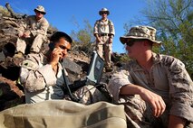 Marines with 1st Air Naval Gunfire Liaison Company, I Marine Expeditionary Force work together with personnel with various units in 1st Marine Division, in the course of a period of instruction on radio waves during a high frequency communications training exercise aboard Air Force Base Gila Bend, Ariz., Aug. 24, 2015. Marines from different units within I MEF worked together to practice operating different types of communications assets in the HF circuit in order to improve their skills.