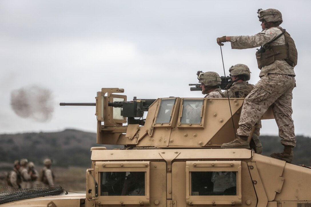 A Marine observes the impact of rounds from Marines with the Combined Anti-Armor Team (CAAT) within Battalion Landing Team (BLT) 2/1, the ground combat element for the 13th Marine Expeditionary Unit, as they fire a .50 caliber heavy machine gun at targets during sustainment training with multiple weapons platforms on Aug. 21, 2015. The CAAT, composed of heavy machine gunners and anti-tank missilemen, is used to combat hardened targets as well as provide security. (U.S. Marine Corps photo by Sgt. Paris Capers /RELEASED)