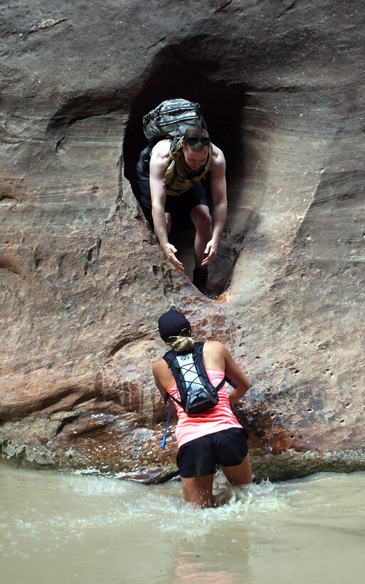 Airman 1st Class Austin Welch, 90th Logistics Readiness Squadron, reaches to help Rachel Bower, F.E. Warren Aquatics Center lifeguard, into a crevice on the side of the Virgin River, Utah, Sept. 5, 2015. Zion was one of four national parks that Airmen visited during an Outdoor Recreation trip over the extended Labor Day weekend. Both Airmen are assigned to F.E. Warren Air Force Base, Wyo. (U.S. Air Force photo by Airman 1st Class Brandon Valle)