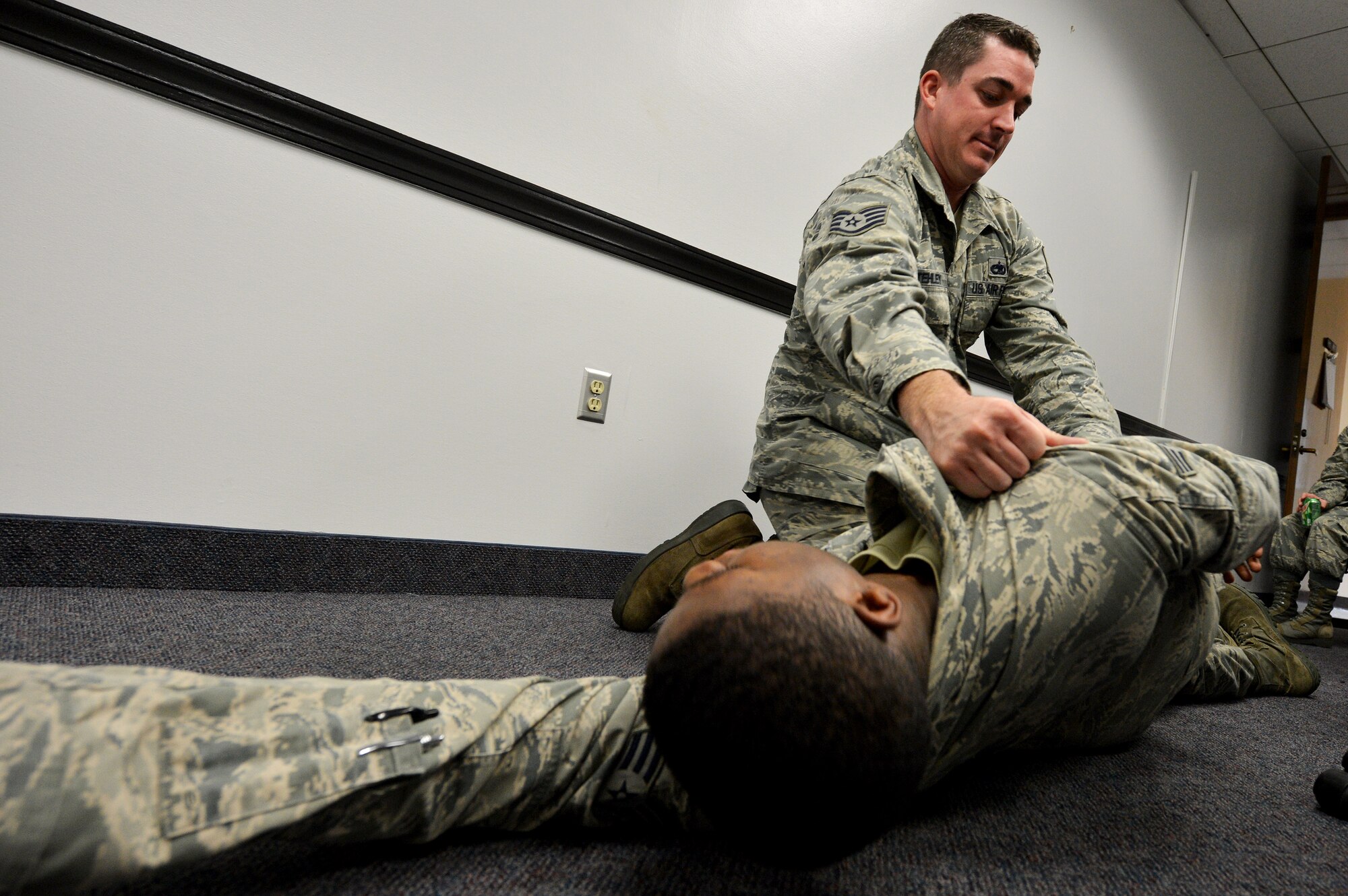 U.S. Air Force Staff Sgt. Patrick Stehley, 20th Fighter Wing CVN logistics manager, safely turns over an Airman during a self-aid and buddy care class at Shaw Air Force Base, S.C., Sept. 3, 2015. The class is offered to provide hands-on techniques that can be used during an emergency situation. (U.S. Air Force photo by Senior Airman Diana M. Cossaboom/Released)